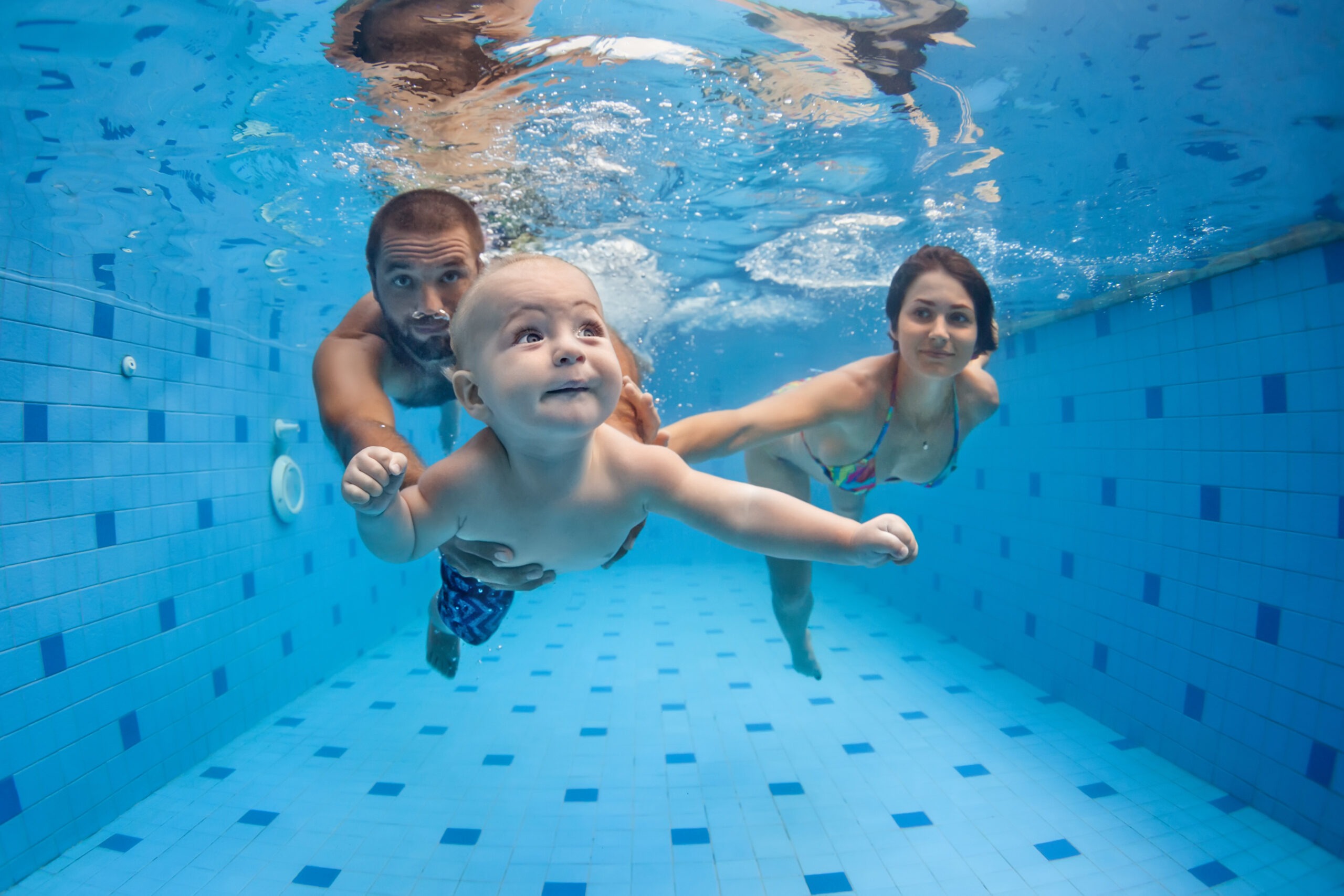 baby swimming with parents
