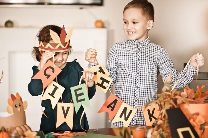 Children holding Thanksgiving decorations.